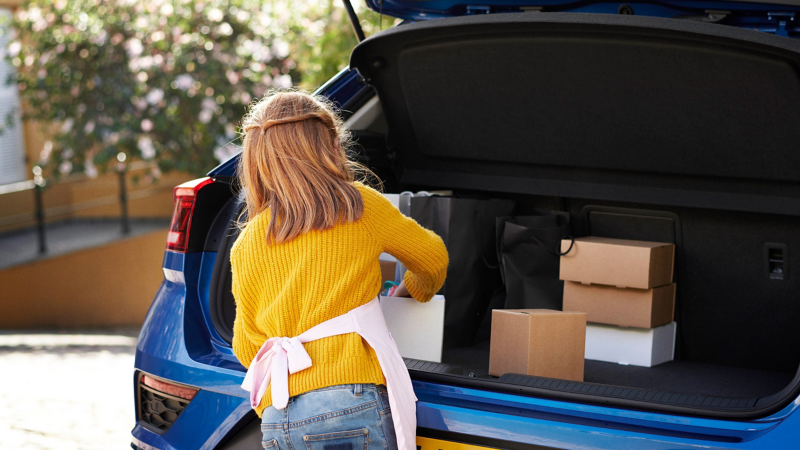 Child removing boxes from the boot of  a Volkswagen car