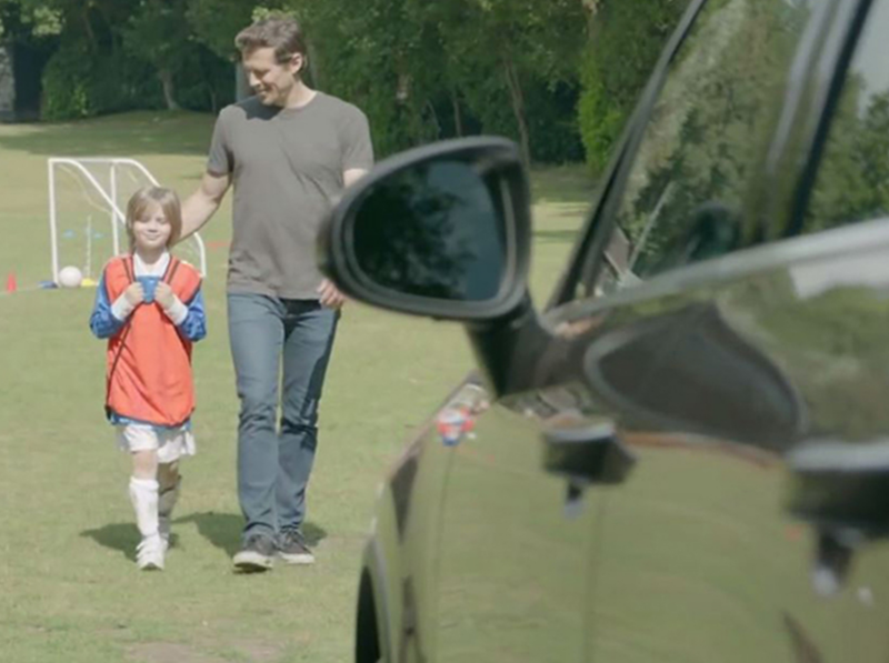 Father and daughter approaching their Volkswagen.