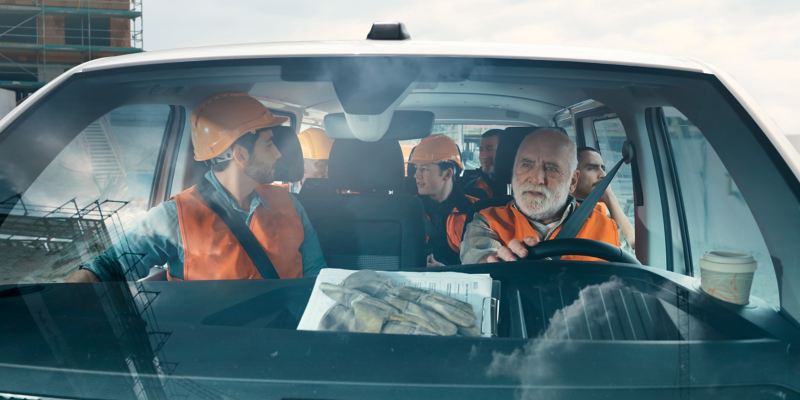 Seven workers are sitting in a Volkswagen Transporter 6.1 Kombi.