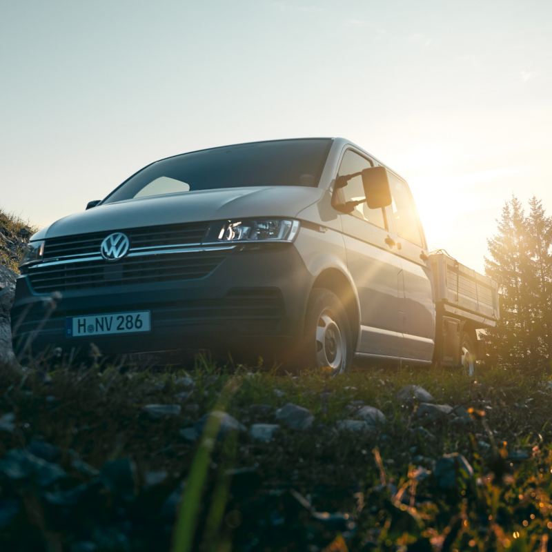Le Transporter 6.1 à plateau est sur une montagne au-dessus des nuages.