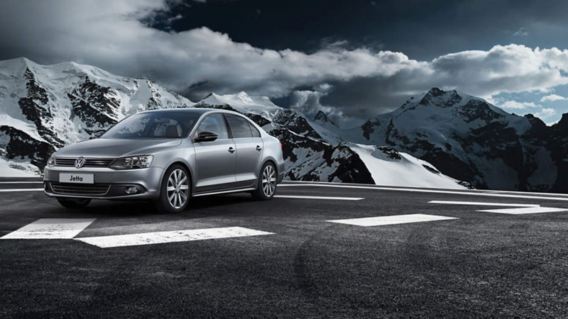 A parked Jetta car next to some mountains