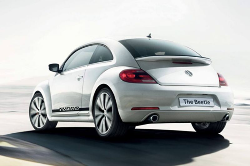 Rear view of a white Volkswagen Beetle Tubro, in a desert. 