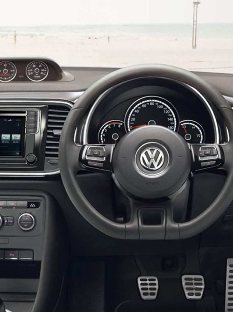 Interior shot of the Volkswagen Beetle dash board and steering wheel.
