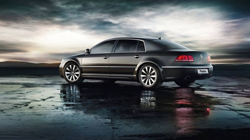 Profile shot of a grey Volkswagen Phaeton, on a wet beach, the tide out.