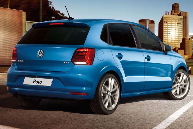 A blue Volkswagen Polo, in a city setting,