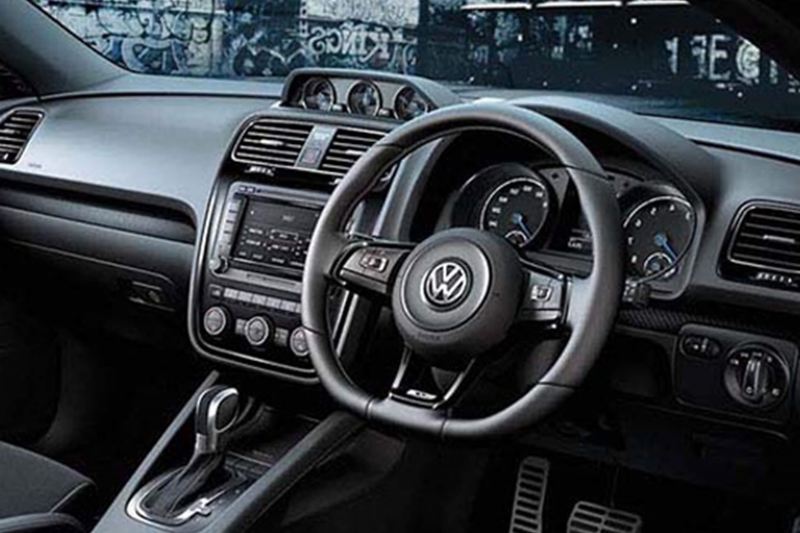 Interior shot of a Volkswagen Scirocco, steering wheel and dashboard.