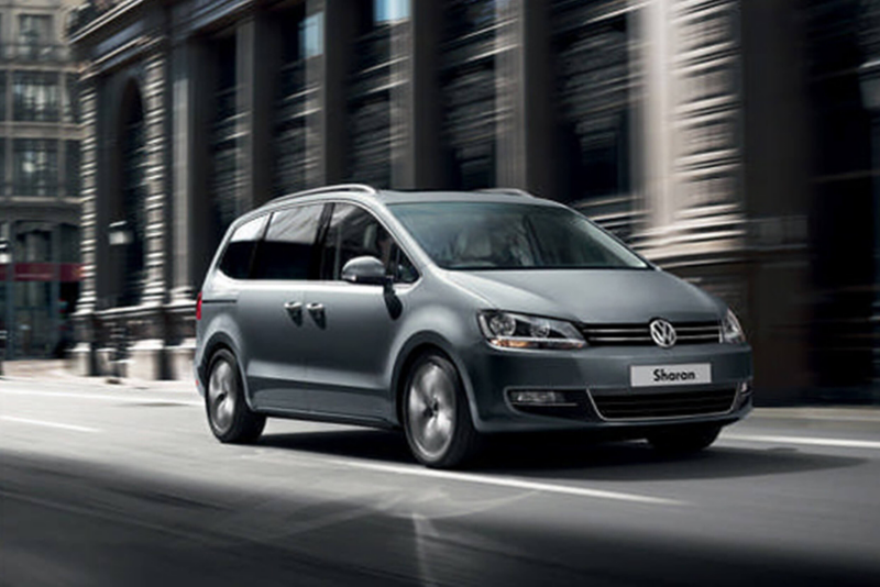 Silver Volkswagen Sharan, driving on a city road.