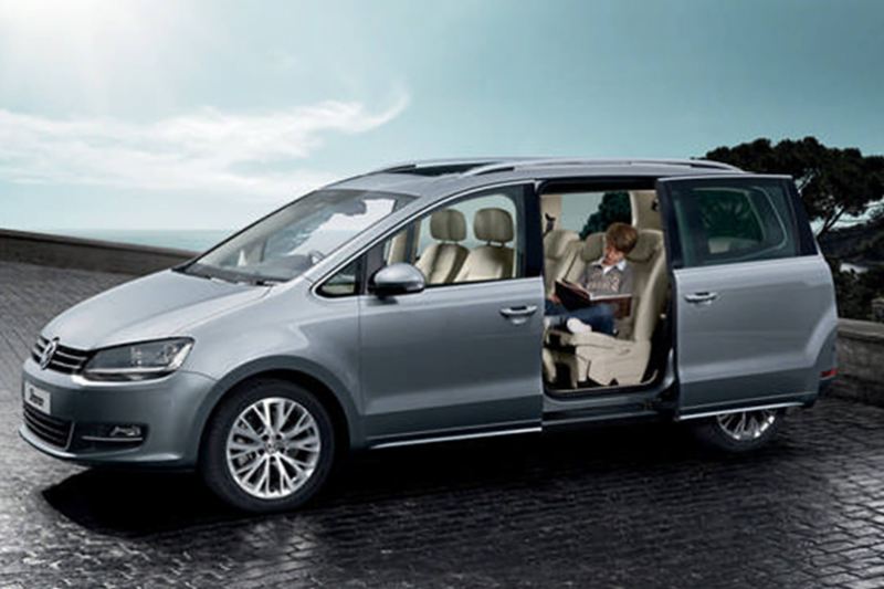 Profile shot of a silver Volkswagen Sharan, the side passenger door open.