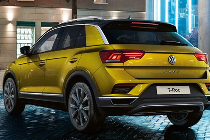 Rear shot of a yellow Volkswagen T-Roc, on a dark brick road.