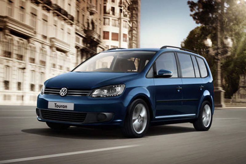 Blue Volkswagen Touran, driving through a city.