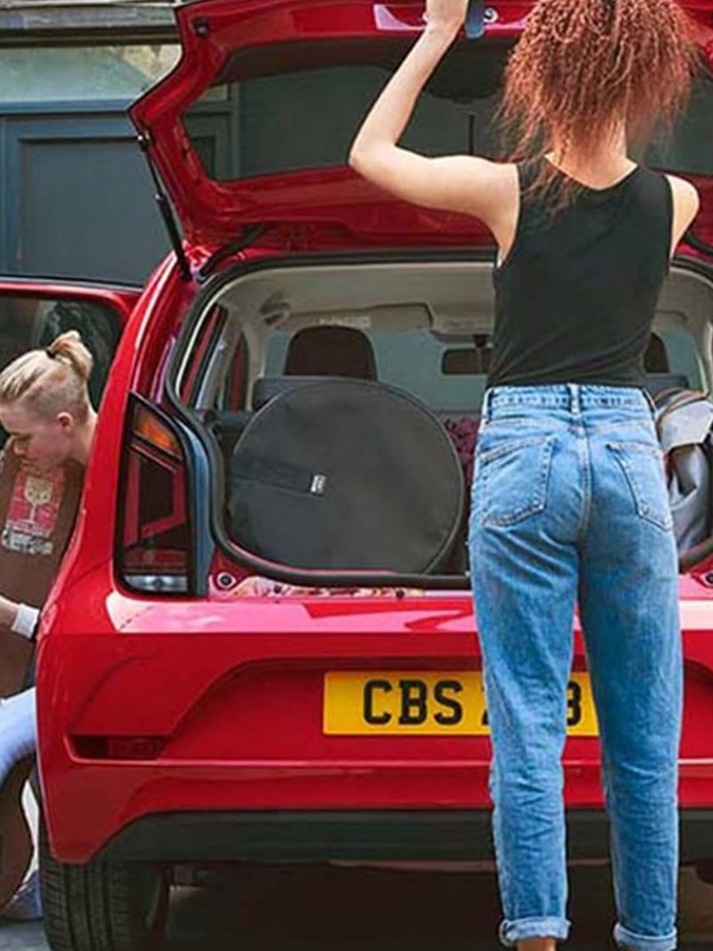 Rear shot of two ladies around a red Volkswagen up!