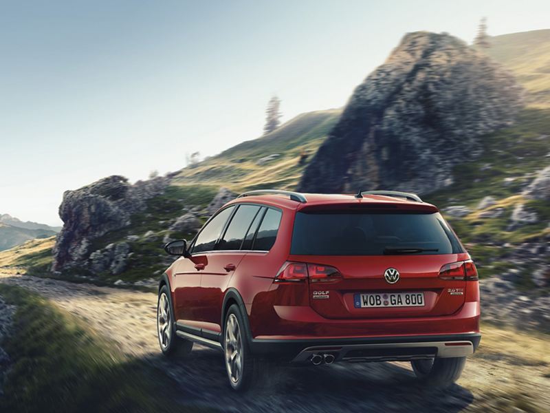 Volkswagen bil åker på kuperad väg i bergstrakter