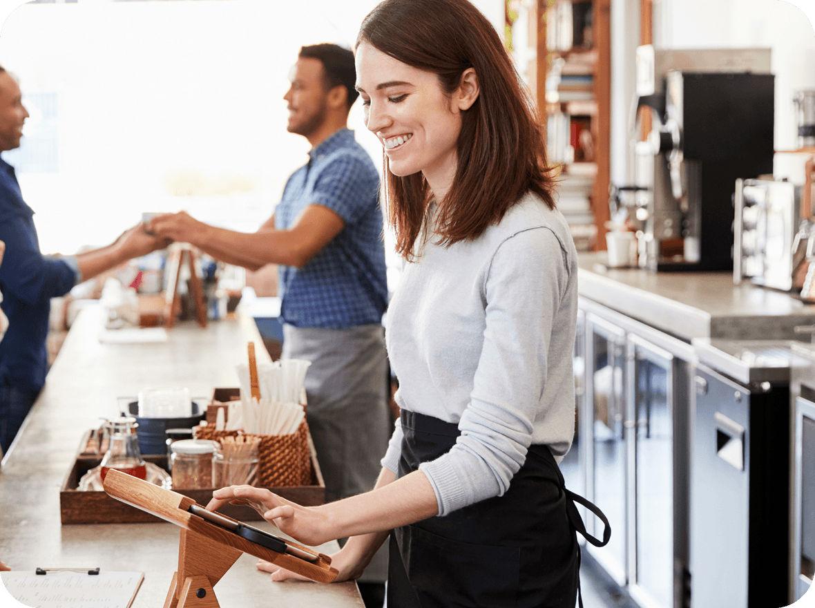 Mitarbeiterin in einem Cafe, die ein Kassensystem bedient