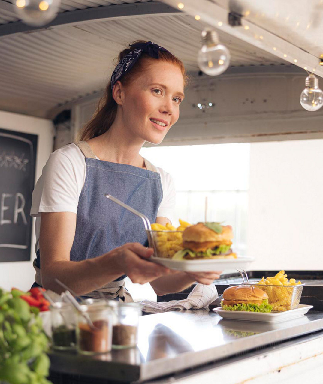 ladie in the foodtruck serving burgers