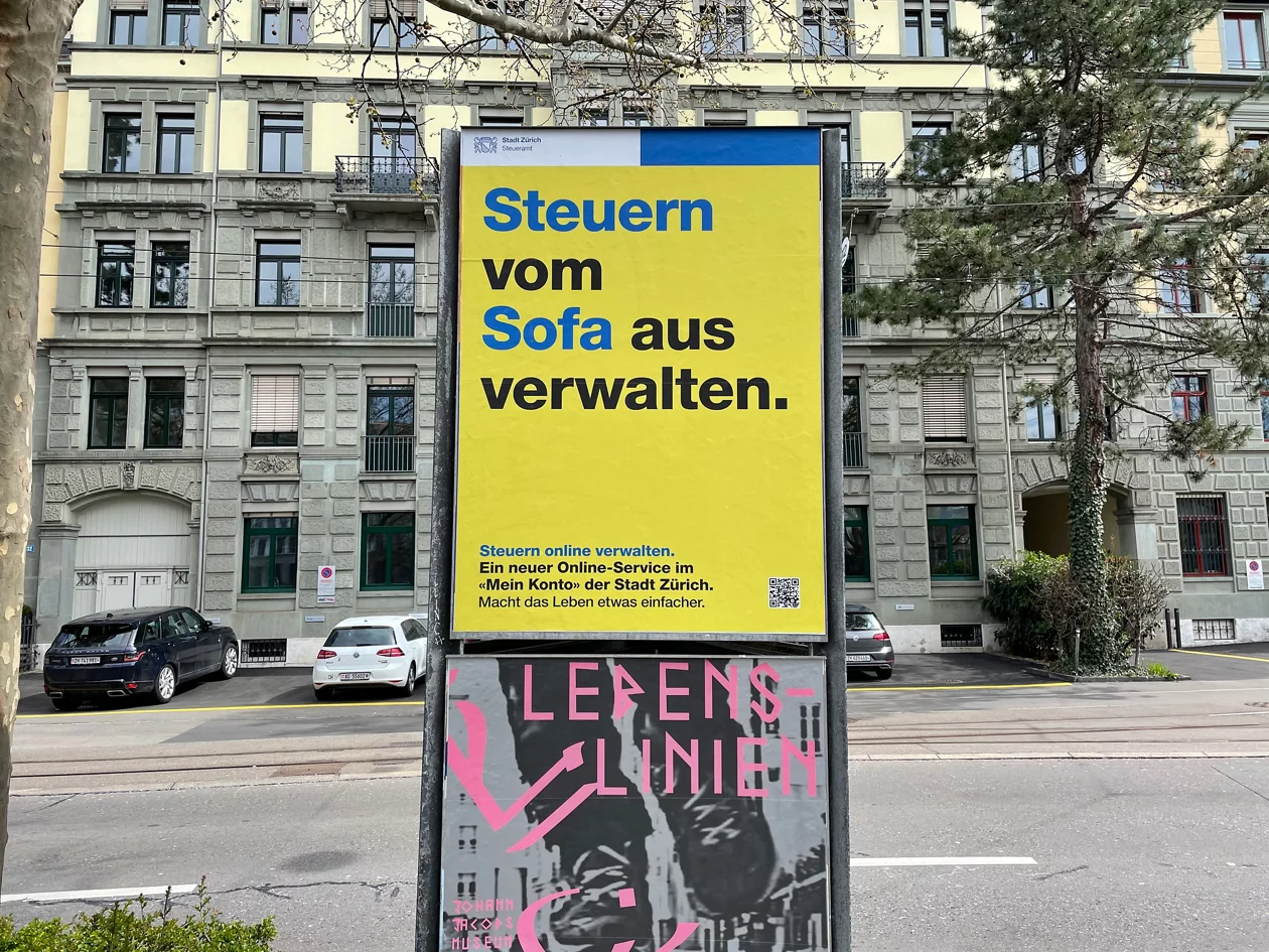 Plakatsäule in der Stadt mit Text Steuern vom Sofa aus verwalten