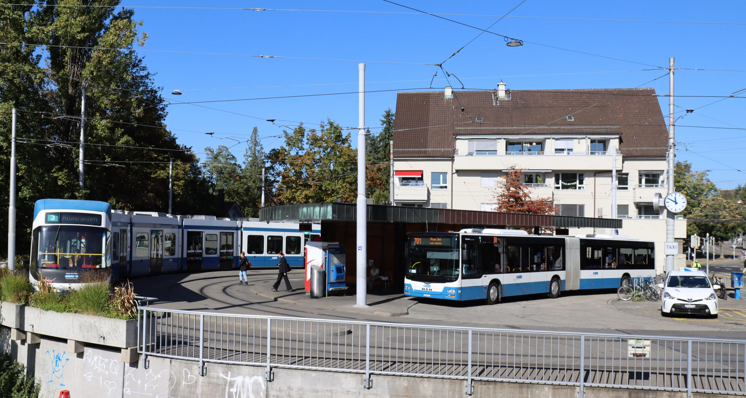 Das Bild zeigt den Klusplatz mit der Wendeschleife und einem wartenden Tram und Bus.