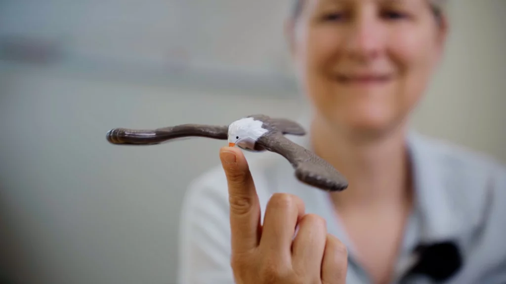 Miriam Herrmann balanciert einen Spielzeug-Adler auf einem Finger
