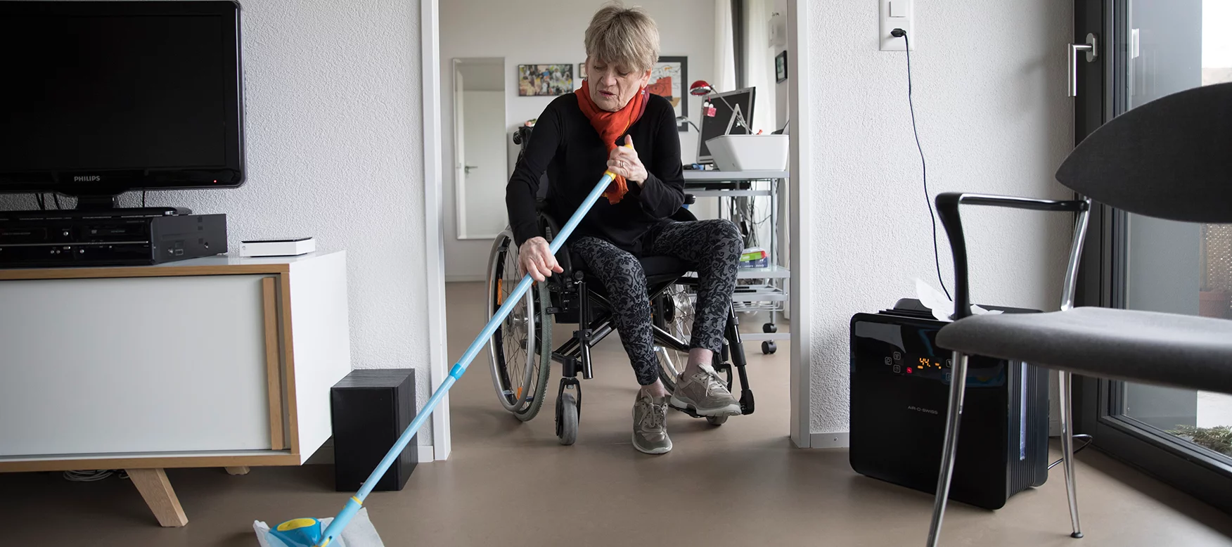 Frau im Rollstuhl in ihrer Wohnung