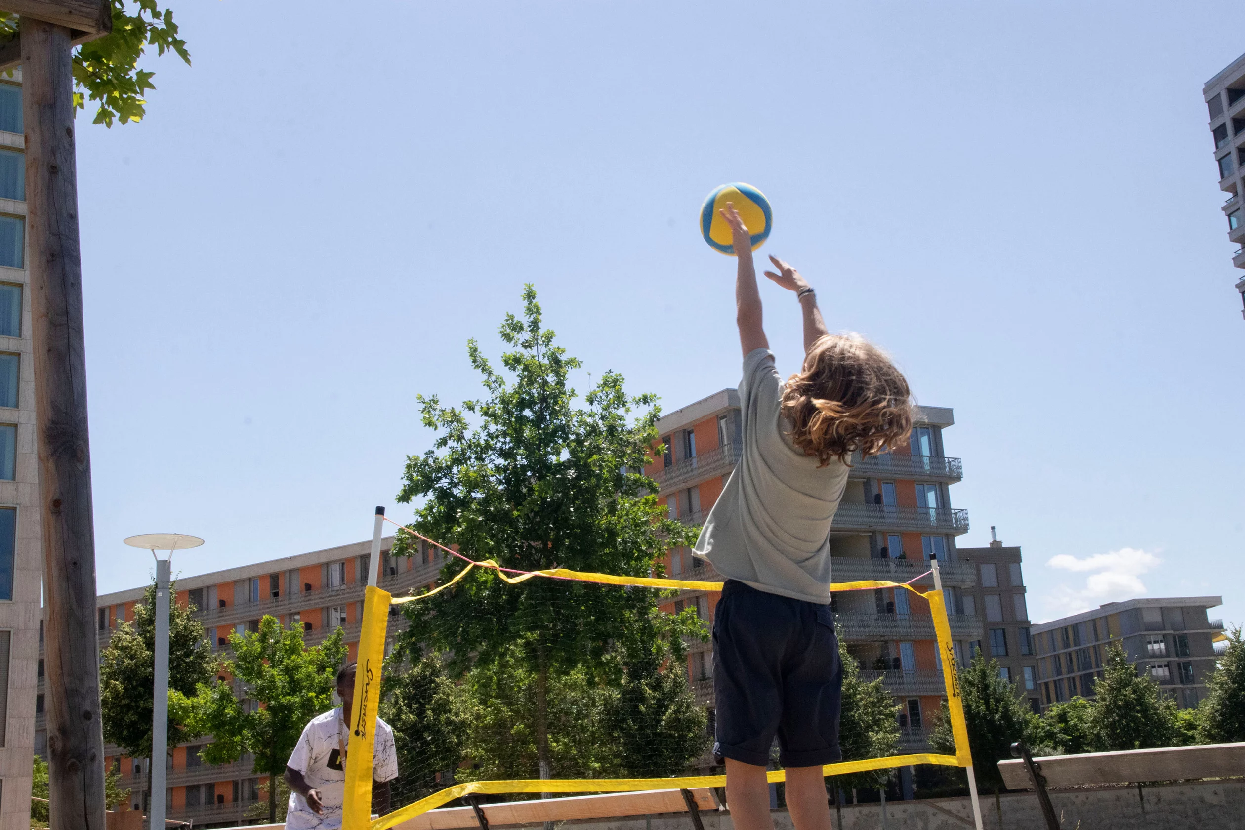 Zwei Jungen spielen Volleyball im Aussenbereich.