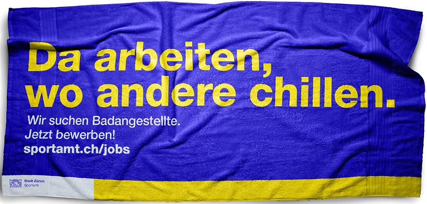Bademeisterin in gelbem Shirt am Schwimmbadrand stehen im Hallenbad Oerlikon.