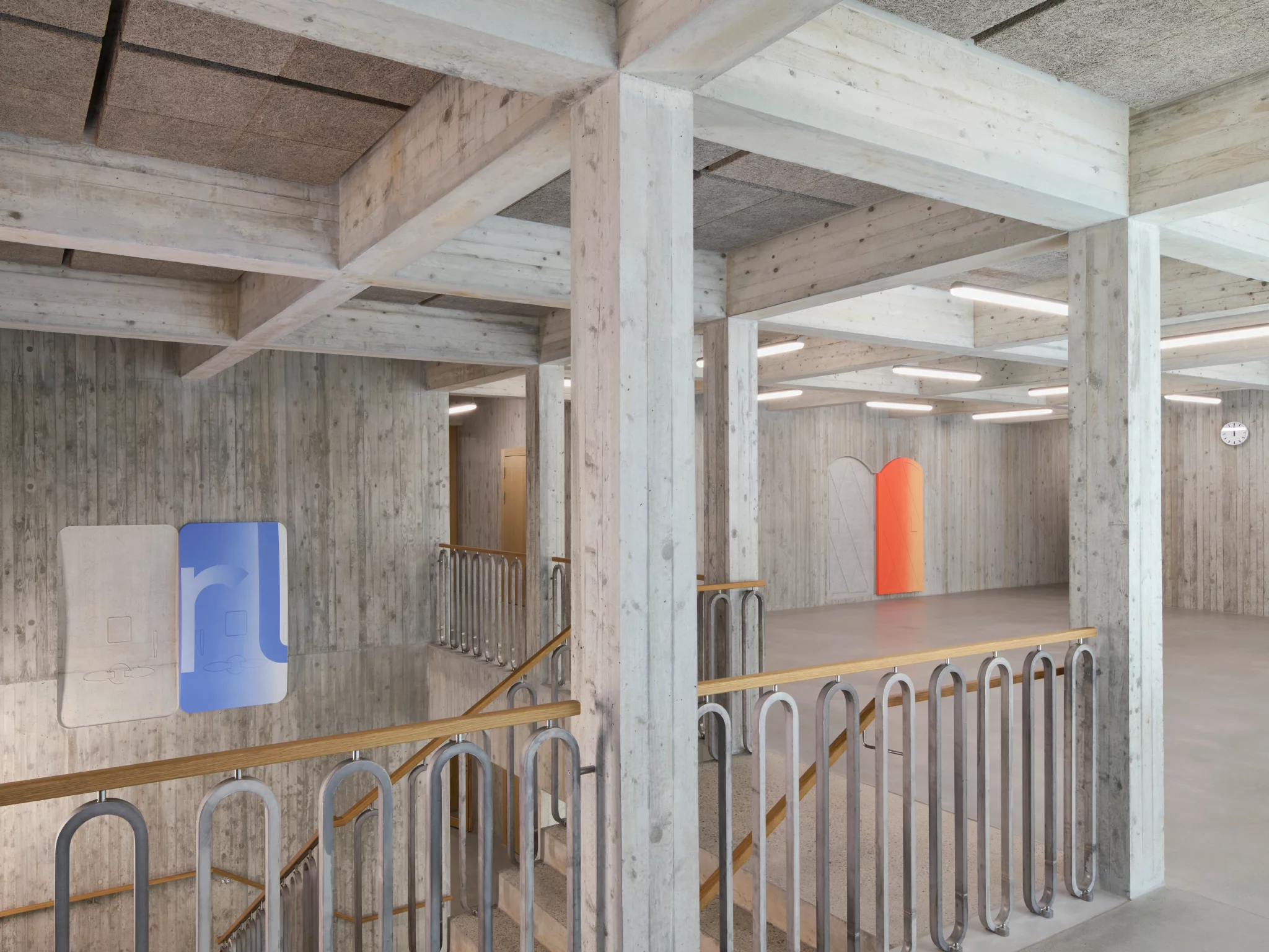 farbige Holztüren mit ihrer Negativform im Beton in einem Treppenhaus