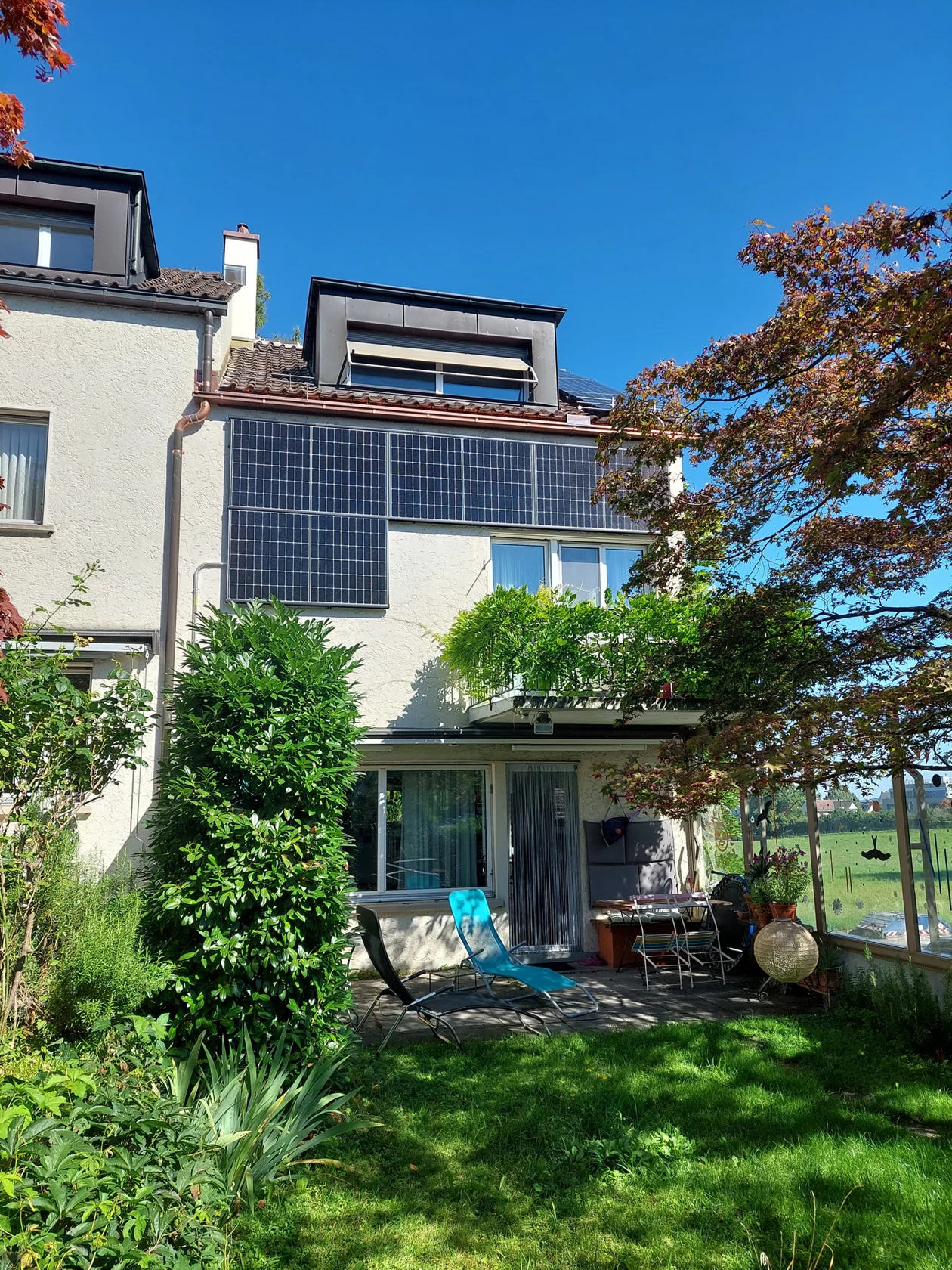 Aussenansicht des Einfamilienhauses mit Solarzellen an der Fassade