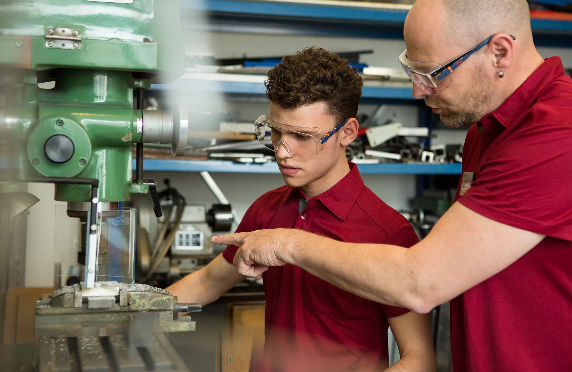 Fachmann Betriebsunterhalt Hausdienst in Ausbildung lässt sich eine Maschine erklären.