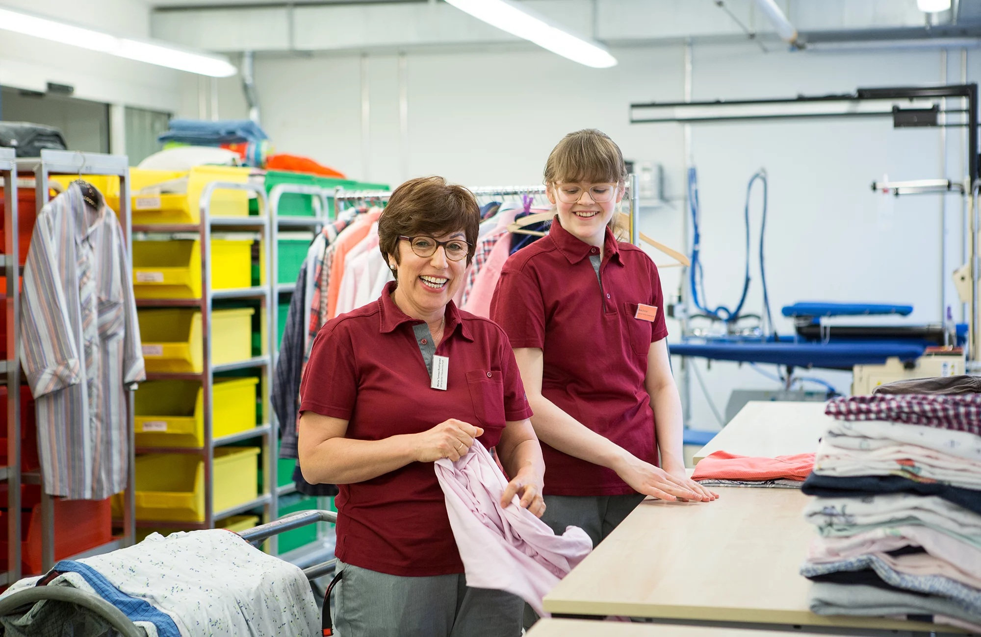 Fachfrau Hotellerie-Hauswirtschaft in Ausbildung zusammen mit einer Mitarbeitenden in der Wäscherei.