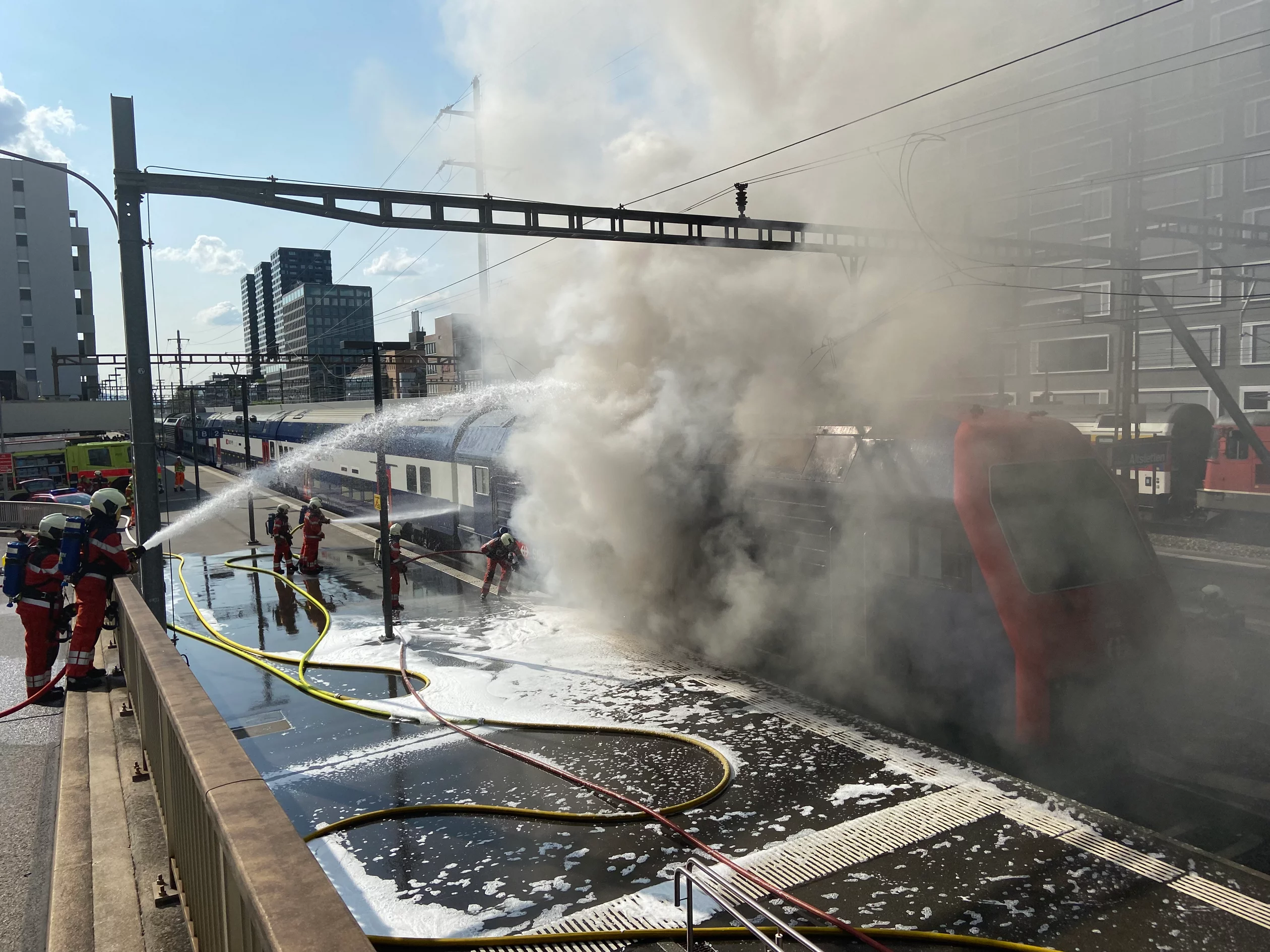 Berufsfeuerwehrleute beim Löschen eines Brandes an einer Lokomotive der S-Bahn. 
