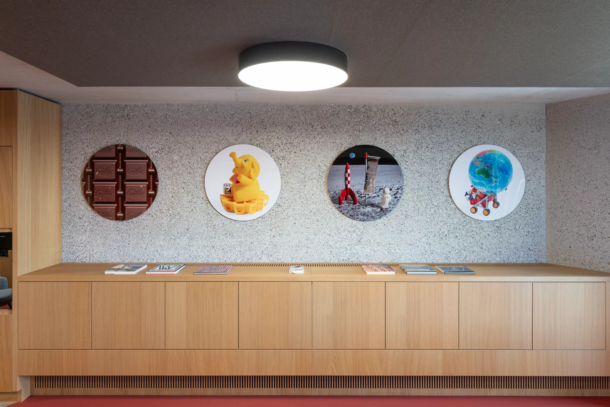 Vier runde Tafeln mit verschiedenen fotografischen Motiven über einem Holzkorpus gehängt