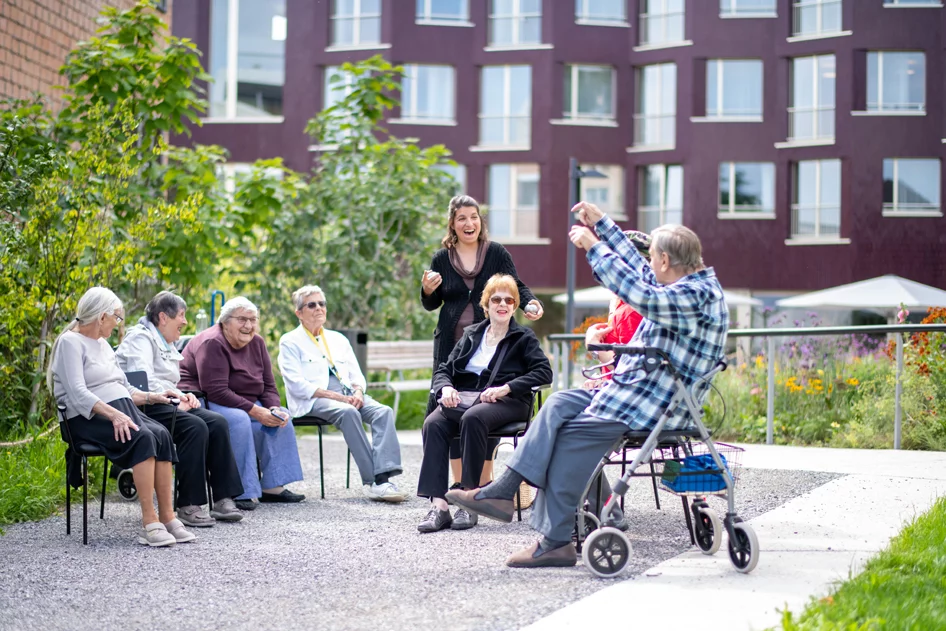 Bewohner*innen und Mitarbeiterin beim Boccia spielen im Garten vom Gesundheitszentrum für das Alter Trotte.