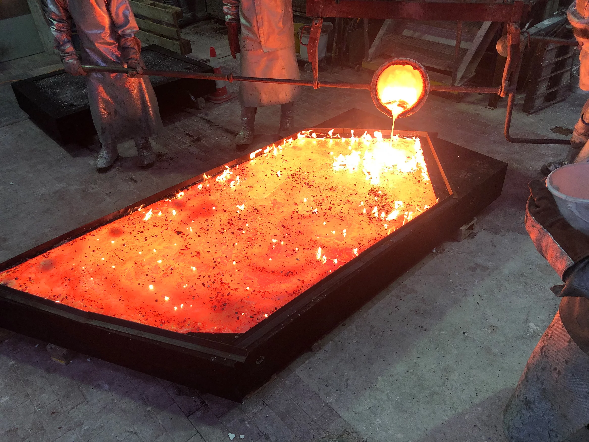 Glühendes, flüssiges Metallgemisch wird in eine Form gegossen