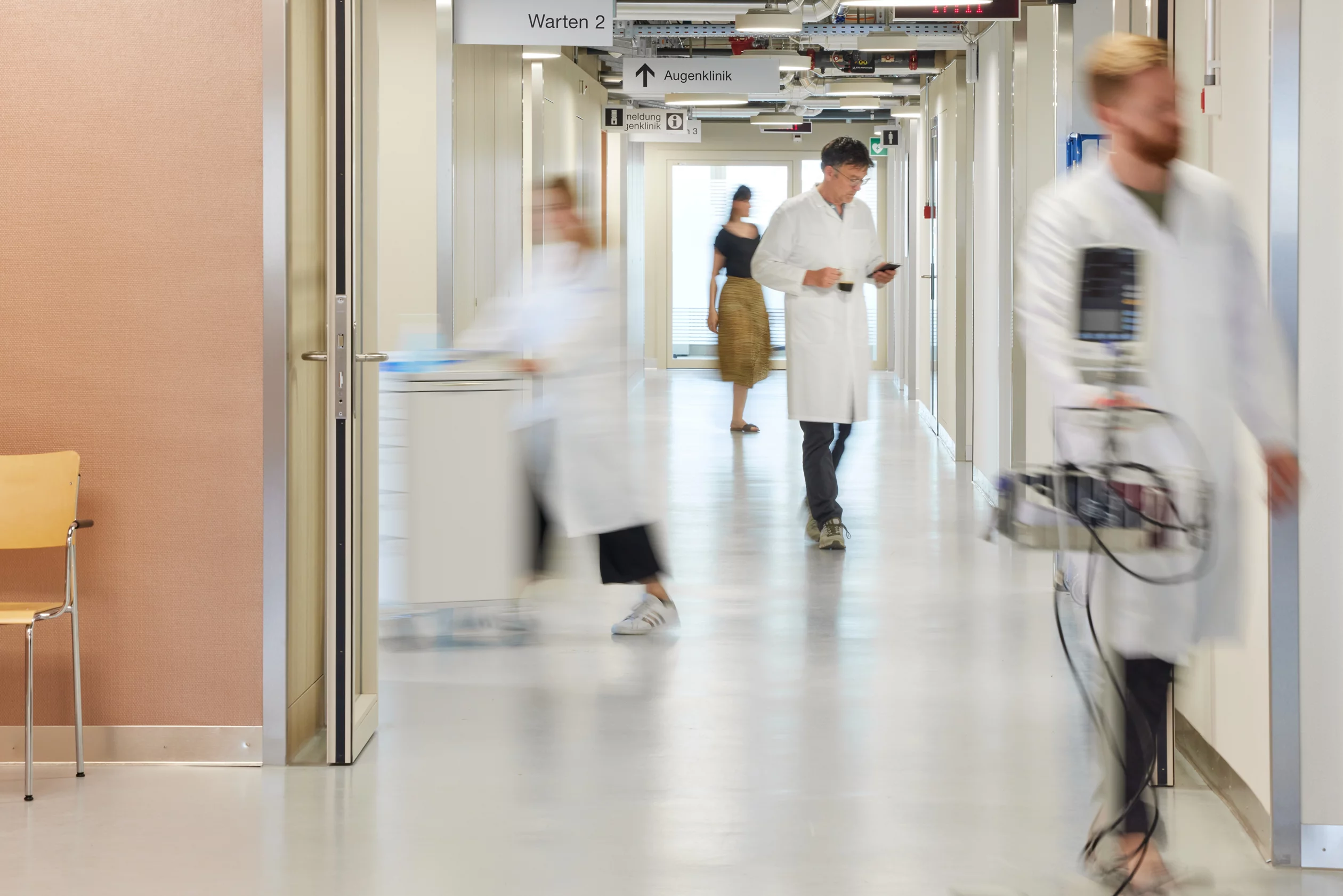 Symbolbild wie es im Spital auf einem Gang aussieht. Mit Pflegenden und Ärtzeschaft