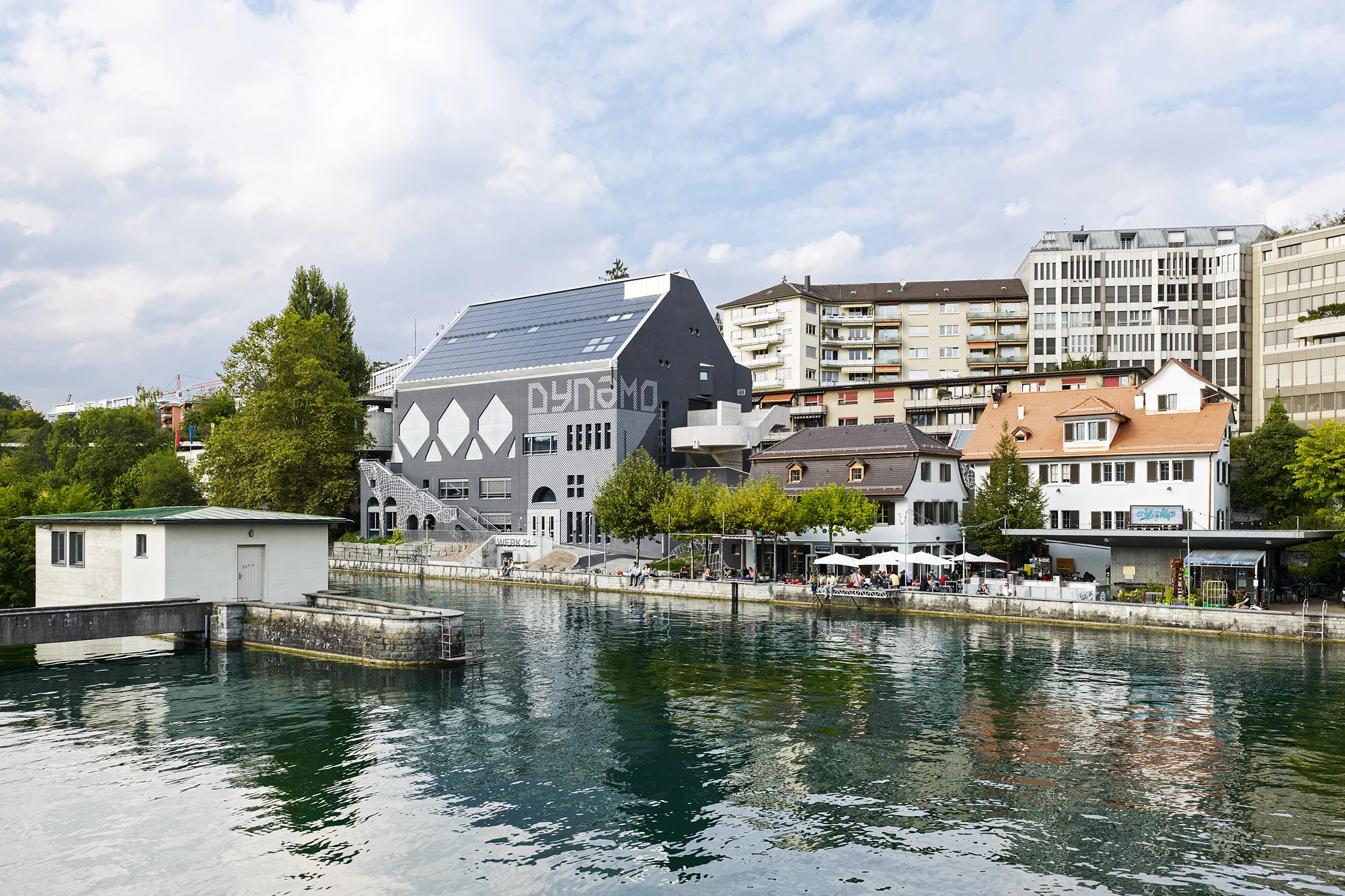 Das Foto wirft einen Blick über die Limmat auf die drei Gebäude des Jugendkulturhaus Dynamo.