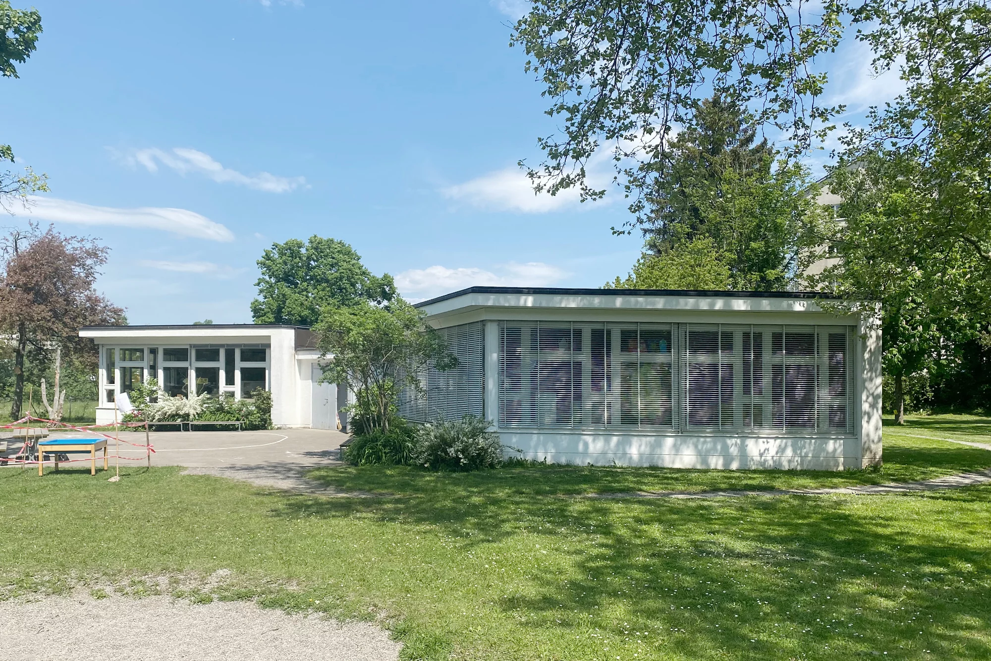 Aussenaufnahme auf Kindergarten Schwandenwies mit Grünanlage.