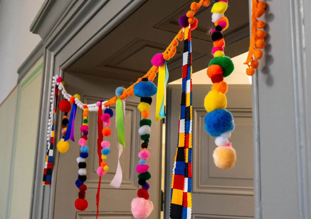 Bunte Girlande in fotografischer Grossaufnahme über einer Eingangstür zum Kindergarten