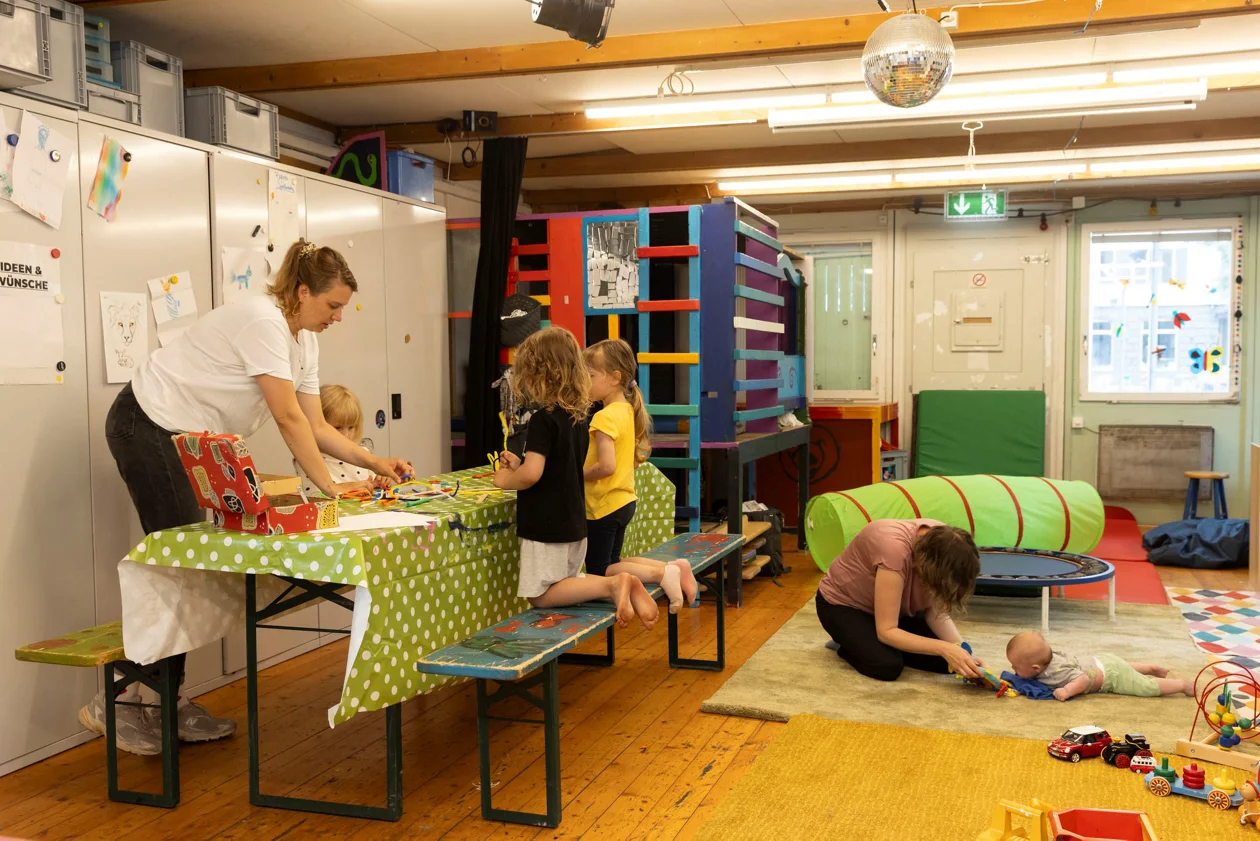 Kinder basteln fleissig mit Papier und Kleber