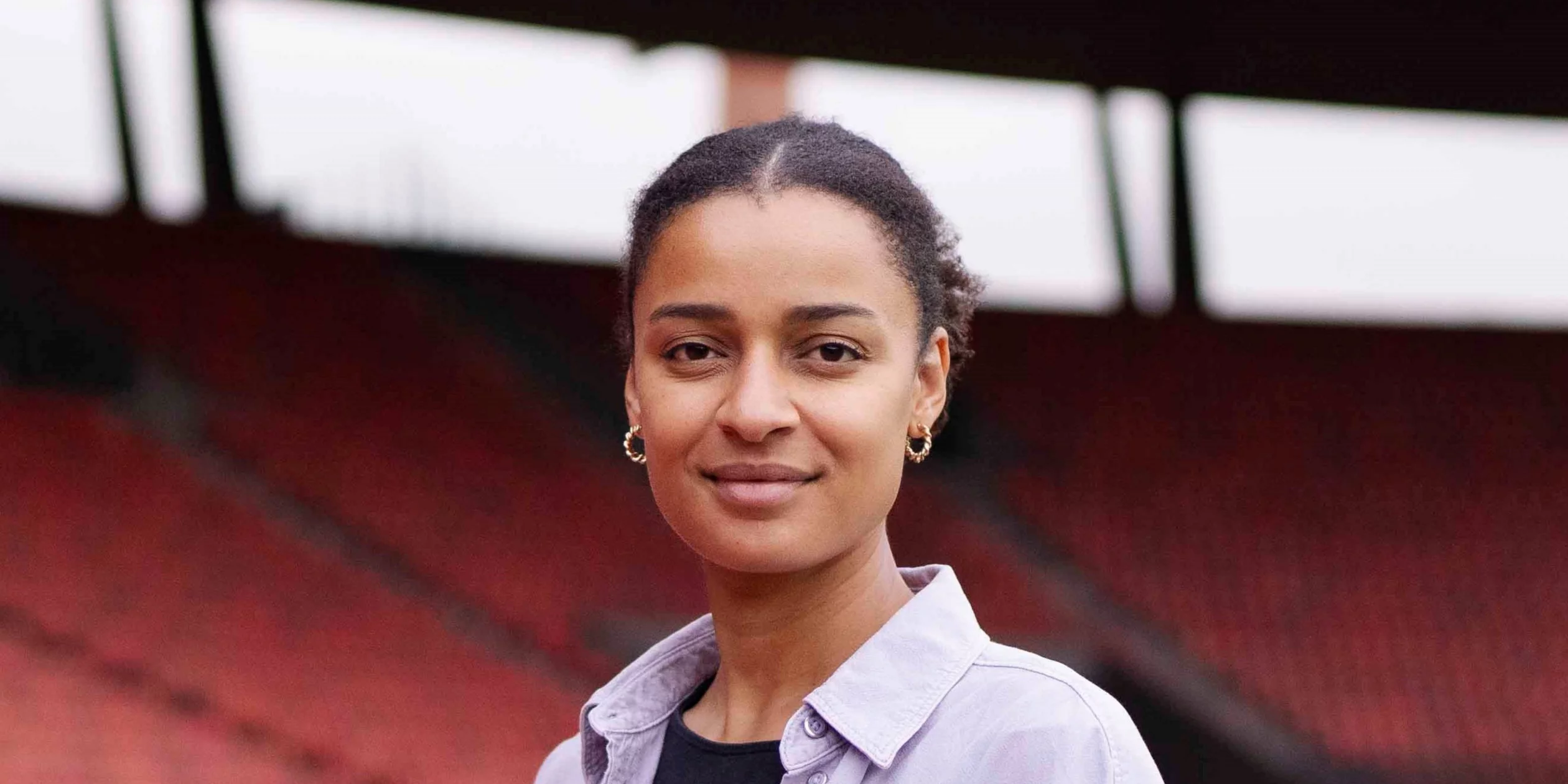 Sarah Akanji steht im Stadion Letzigrund vor leeren Rängen und schaut direkt in die Kamera.