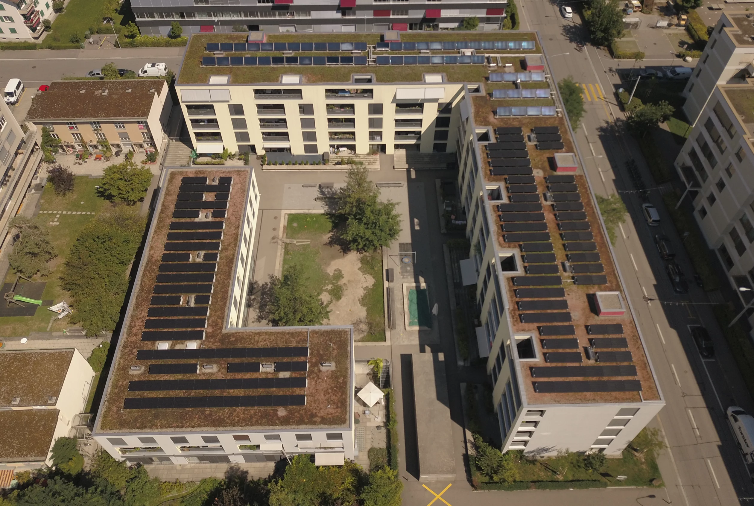 Luftaufnahme der Mehrfamilienhäuser im Kreis 9 mit Solarzellen auf dem Dach