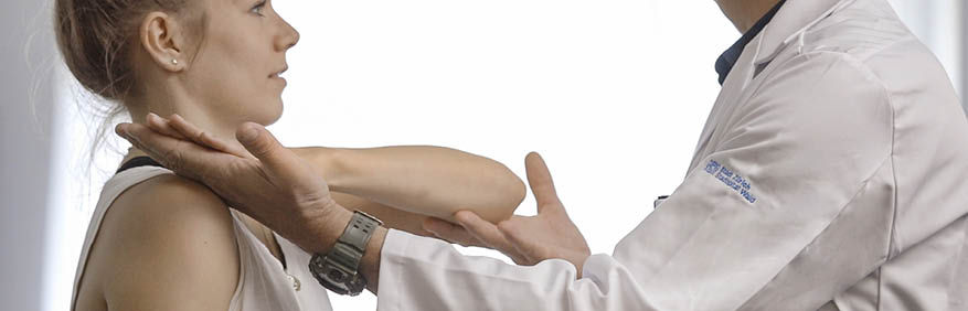 Patientin in der Behandlung. Beweglichkeit des Arms wird getestet