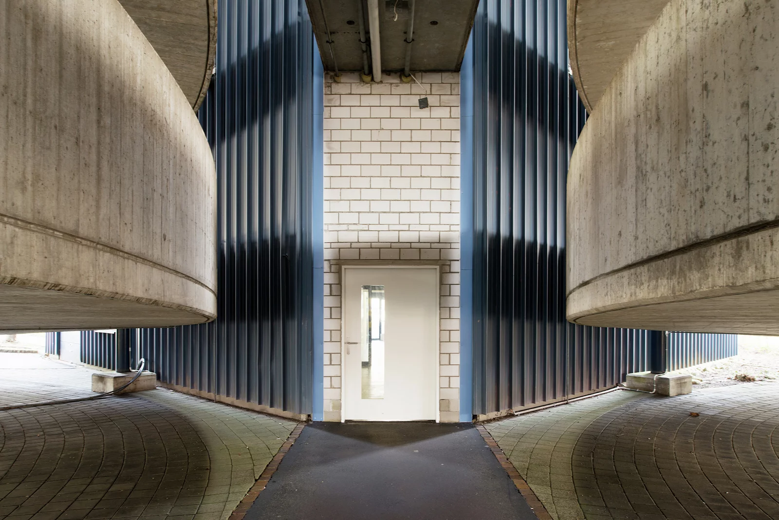 Weisse Tür umgeben von blauen Säulen. Bild: Juliet Haller