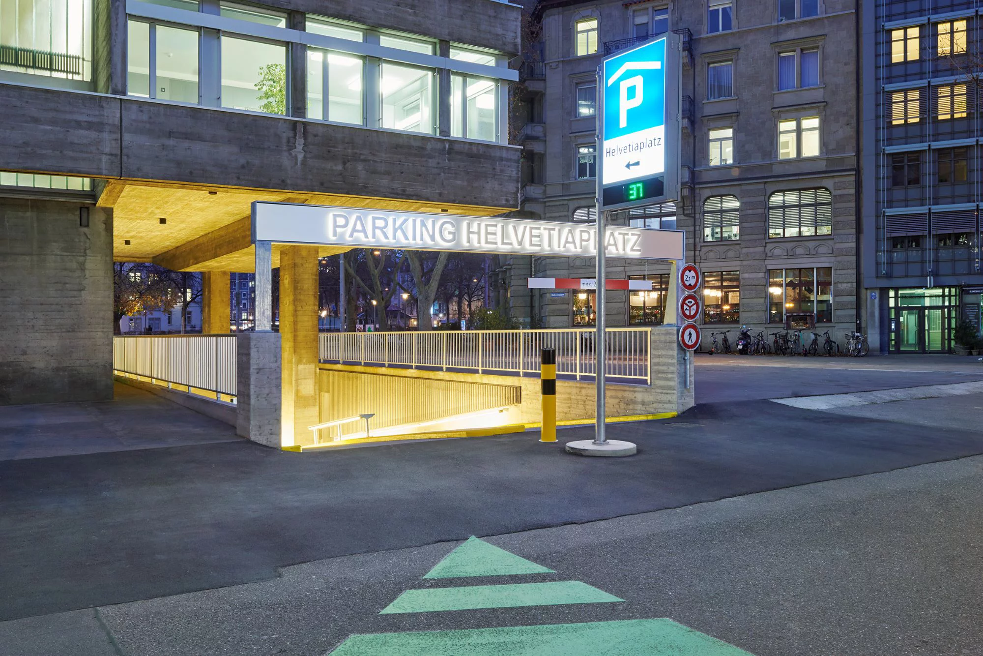 Erleuchteter Eingang zum Parkhaus mit blauer Anzeigetafel. Bild: Luca Zanier