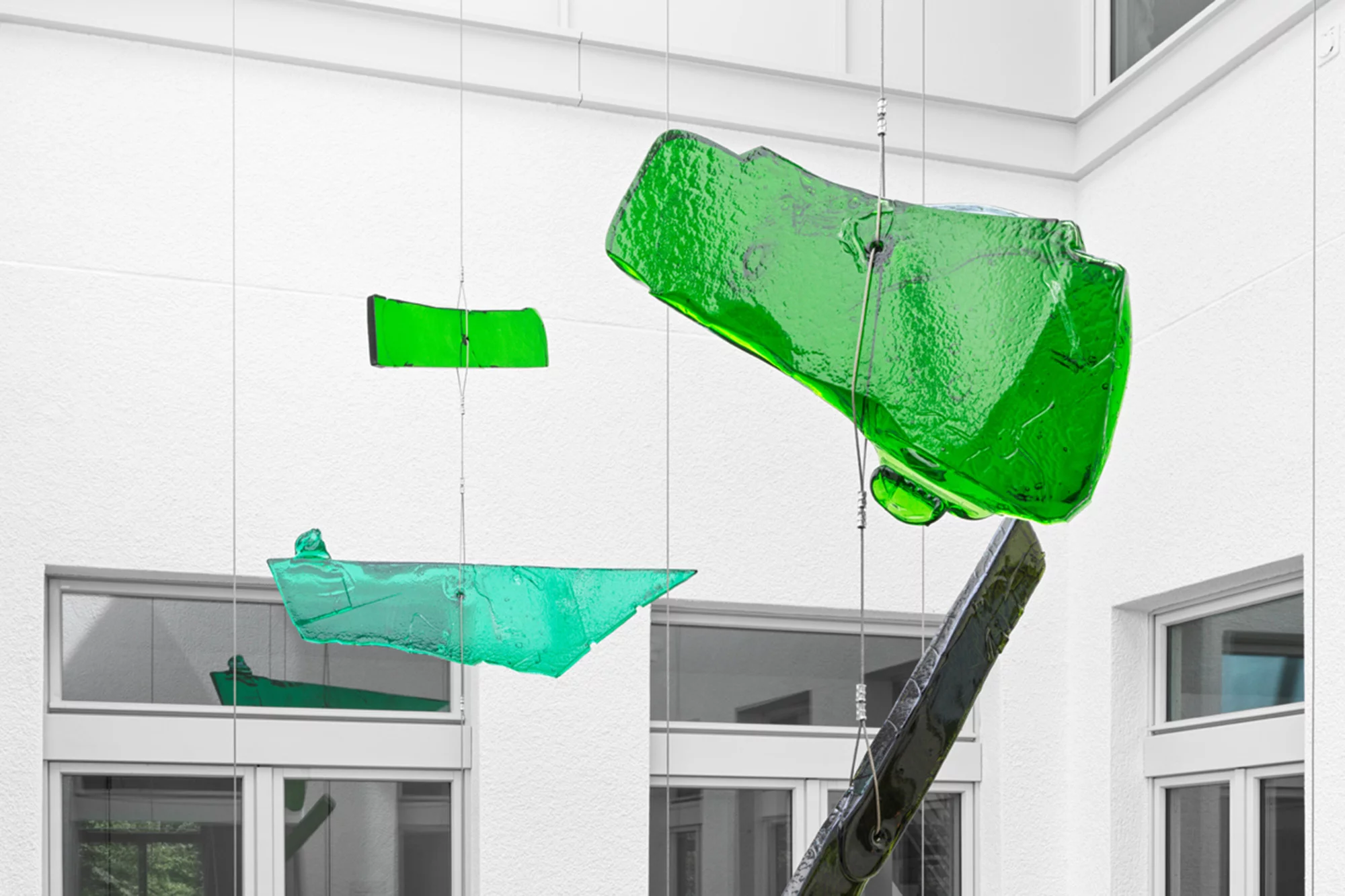 eine Kunstinstallation aus grünem Glas im Lichthof