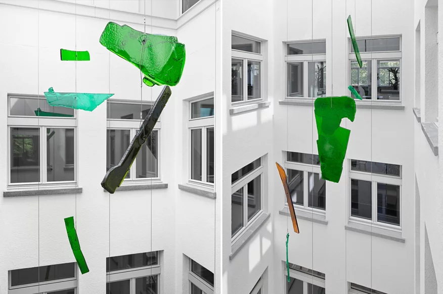 Im Lichthof schwebende grüne Glaselemente