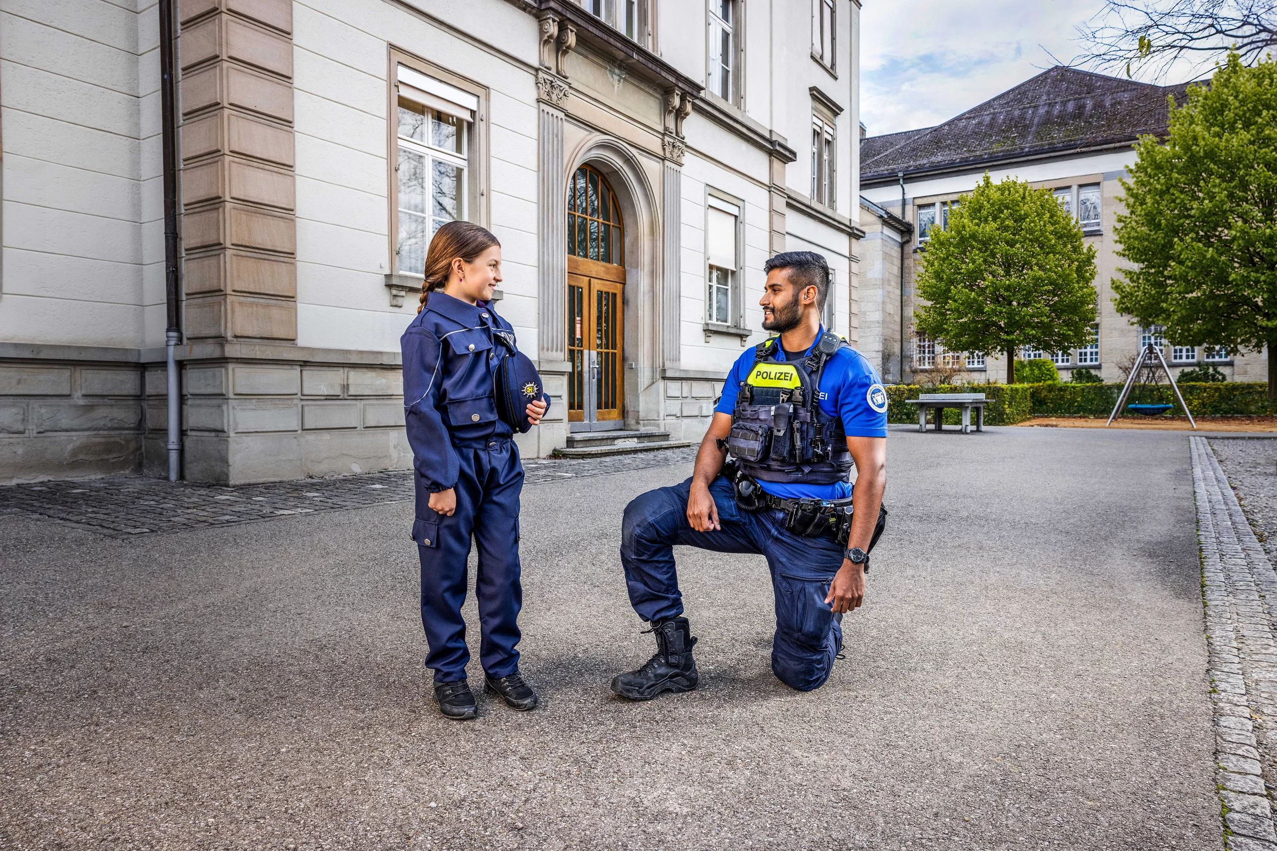 Zwei Polizist*innen bei Polizeiauto am Abend.