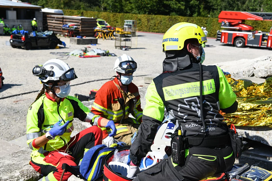 Einsatzkräfte versorgen nach einem Trümmerunfall eine verunglückte Person.