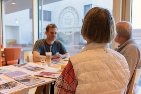 Informelles Gespräch im Café: ZiA-Mitarbeiter mit Senior*innen aus dem Quartier