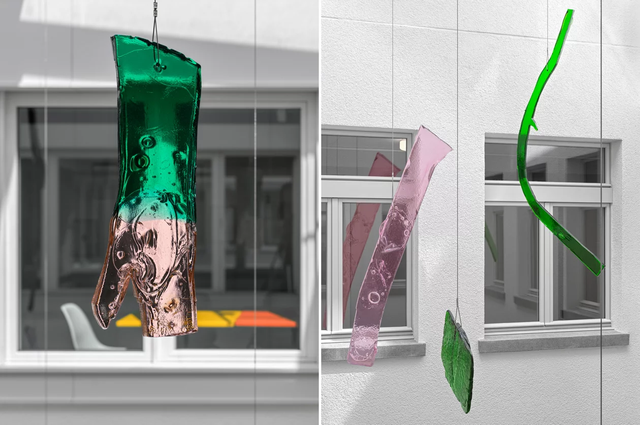 Ansicht Lichthof der schwebenden Glaselemente in rosa und grün