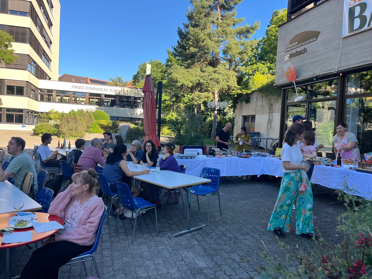 Tische mit essenden Menschen an der Tavolata im GZ Riesbach