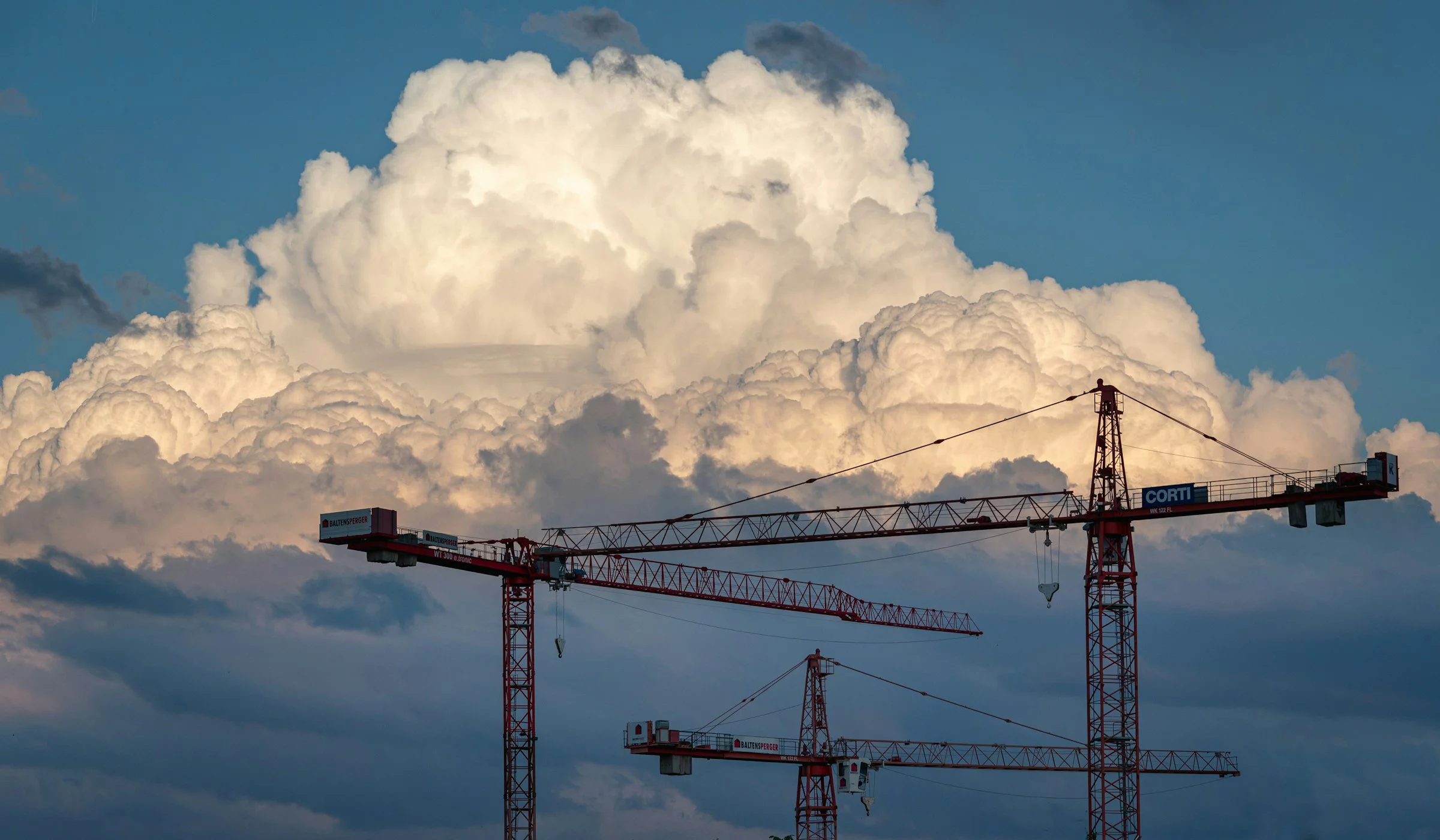 Baukräne mit einer grossen Wolke im Hintergrund